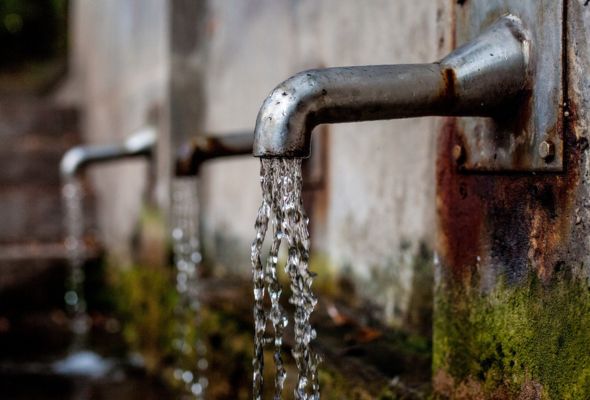 Menifee homeowner shutting off water after a burst pipe